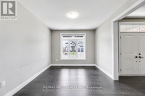 Thames Centre apartment for rent - A room with a large window showing a view of a house and trees.