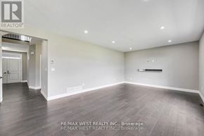Thames Centre apartment for rent - A spacious room with wooden flooring and white walls, brokerage by RE/MAX West Realty Inc.