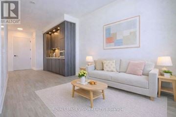 Toronto (Dovercourt-Wallace Emerson-Junction) condo for rent - A living room with a grey couch, a wooden coffee table, and a painting on the wall.