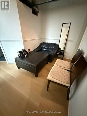 Toronto (Highland Creek) apartment for rent - A black leather sofa and chair in a white room.