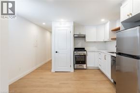 Hamilton apartment for rent - A kitchen with white cabinets and a black refrigerator.