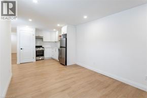 Hamilton apartment for rent - A white kitchen with wooden floors and a refrigerator.