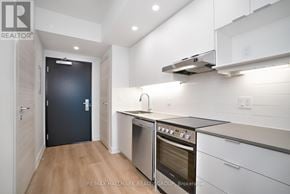 Ottawa condo for rent - A modern kitchen with a black door and white cabinets.