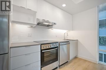 Ottawa condo for rent - A kitchen with white cabinets and stainless steel appliances.