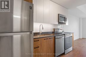 Ottawa condo for rent - A kitchen with a refrigerator and a microwave.