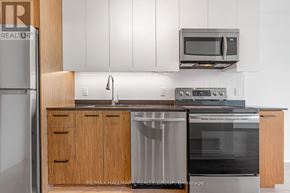 Ottawa condo for rent - A kitchen with a refrigerator, microwave, oven, and cabinets.