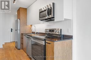 Ottawa condo for rent - A modern kitchen with stainless steel appliances and wooden cabinets.