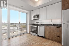 Ottawa condo for rent - A kitchen with white appliances and wooden cabinets.