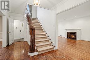 Toronto (Lawrence Park South) apartment for rent - A large, open living room with a fireplace and a staircase with a wooden handrail.