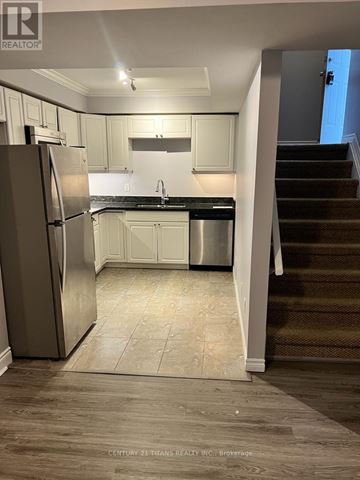 Oshawa (Donevan) apartment for rent - A kitchen with white cabinets and a stainless steel dishwasher and refrigerator.