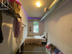 Toronto (Dovercourt-Wallace Emerson-Junction) apartment for rent - A small bedroom with a bed, a window, and a clothing rack.