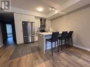 Guelph (Kortright East) townhouse for rent - A kitchen with a refrigerator, stove, and sink.