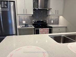 Guelph (Kortright East) townhouse for rent - A kitchen with a stove top oven and a refrigerator.