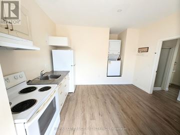 London East (East L) multi-family for rent - A kitchen with white appliances and wooden floors.
