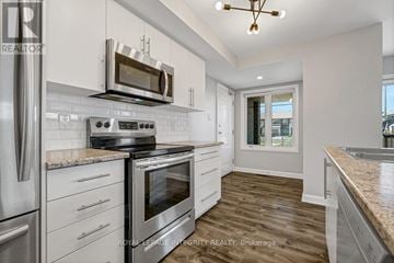 Ottawa condo for rent - A kitchen with a stove top oven and microwave above it.