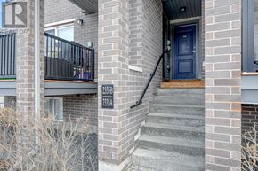 Ottawa condo for rent - A brick building with a blue door and a balcony with a black railing.