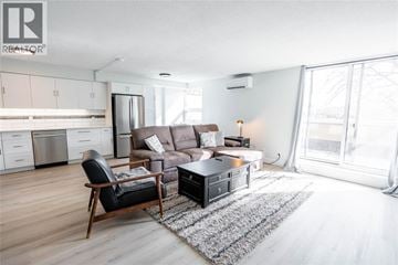 Sarnia condo for rent - A living room with a brown couch and a black chair.