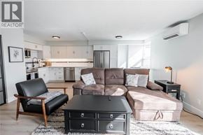 Sarnia condo for rent - A living room with a brown couch and a black chair.