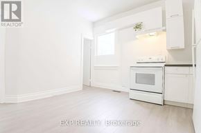 Toronto (East York) apartment for rent - A white kitchen with EXP REALTY Brokerage written on the bottom.