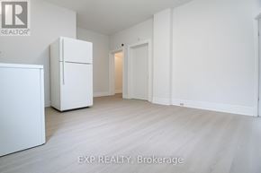 Toronto (East York) apartment for rent - A white refrigerator is in a white room with a white door.