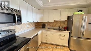 Markham (Thornhill) condo for rent - A kitchen with white cabinets and a black stove top oven.