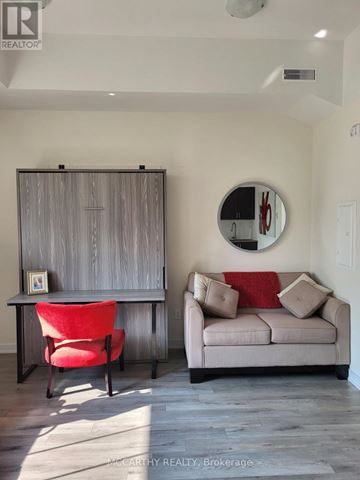 Southgate condo for rent - A living room with a red chair and a grey couch.