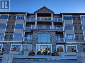 Southgate condo for rent - A large apartment building with the sign "McCarthy Realty, Brokerage" in front.