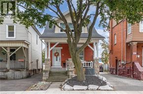 Hamilton apartment for rent - A house with a red front door and a tree in front.