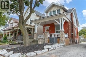 Hamilton apartment for rent - A house with a red brick exterior and a large tree in front.