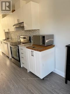 Toronto (Mount Pleasant East) apartment for rent - A kitchen with white cabinets and a wooden countertop.