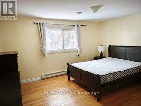 Toronto (L'amoreaux) apartment for rent - A bedroom with a bed, nightstand, and window.