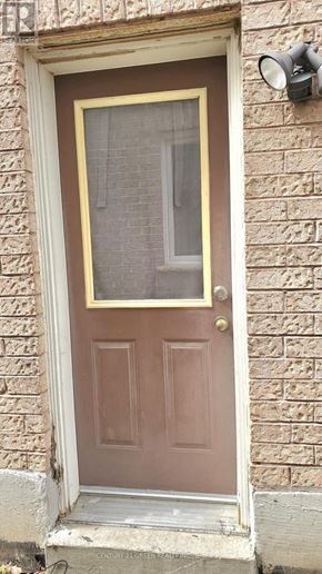 Whitby (Pringle Creek) apartment for rent - A brown door with a glass window is set in a brick wall.