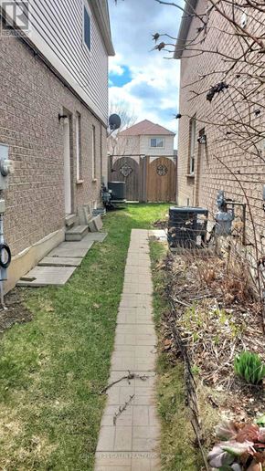 Whitby (Pringle Creek) apartment for rent - A narrow alley with a brick wall on one side and a wooden fence on the other.