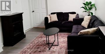 Whitby (Pringle Creek) apartment for rent - A living room with a black couch and a small table.