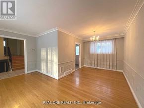 Markham (Bullock) apartment for rent - A spacious room with wooden floors and a chandelier.