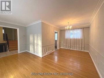 Markham (Bullock) apartment for rent - A spacious room with wooden floors and a chandelier.