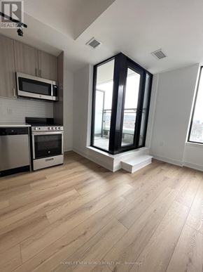 Toronto (Dovercourt-Wallace Emerson-Junction) condo for rent - A modern kitchen with wooden flooring and a large window.
