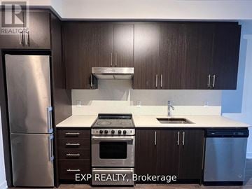 Hamilton (Beasley) condo for rent - A kitchen with dark wood cabinets and stainless steel appliances.