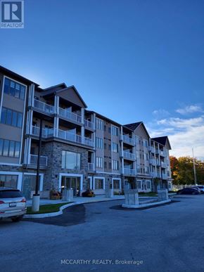 Southgate condo for rent - A large apartment complex with a car parked in front.