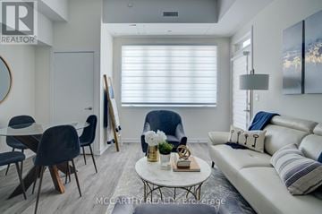 Southgate condo for rent - A living room with a white couch, a coffee table, and a painting on the wall.