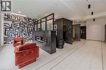 Waterloo condo for rent - A living room with a red chair and a black and white patterned wall.