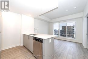 Ottawa condo for rent - A kitchen with a stainless steel dishwasher and a window overlooking a cityscape.