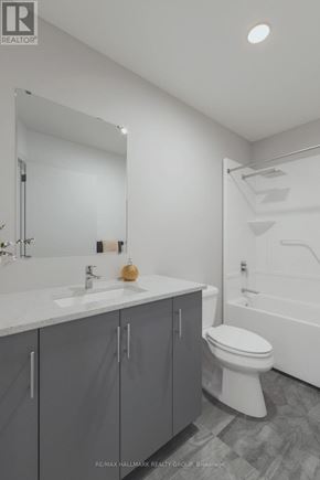 Ottawa condo for rent - A bathroom with a white toilet, sink, and bathtub.