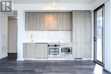 Toronto (Church-Yonge Corridor) condo for rent - A modern kitchen with wooden cabinets and a marble countertop.