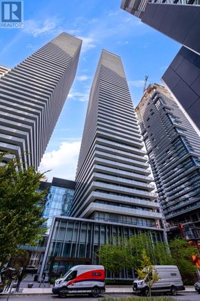 Toronto (Church-Yonge Corridor) condo for rent - Two tall buildings with a red van parked in front of them.