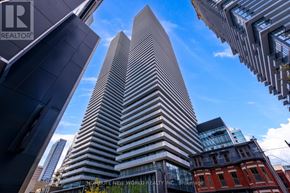 Toronto (Church-Yonge Corridor) condo for rent - A tall building with a modern design stands in the center of a cityscape.