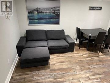 Vaughan (Vaughan Grove) apartment for rent - A living room with a black sofa and a wooden floor.