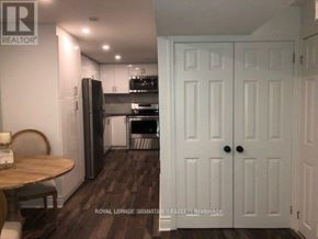 Vaughan (Vaughan Grove) apartment for rent - A kitchen with a table and chairs in front of a refrigerator.