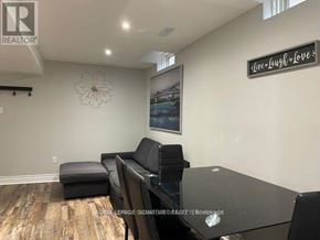 Vaughan (Vaughan Grove) apartment for rent - A living room with a black couch and a glass table.