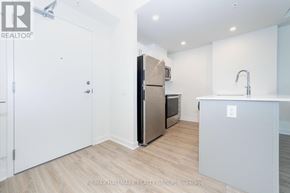 Ottawa condo for rent - A kitchen with a refrigerator, sink, and cabinets.